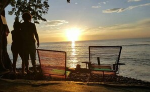 Enjoy a serene beachside moment with two chairs facing the ocean.