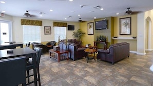 A spacious living area with a dining table, sofas, and a TV mounted on the wall. - Private Pool Home-popular Resort Near Disney! (Kissimmee)