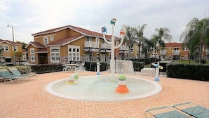 A courtyard with a water fountain, lounge chairs, and a fence. - Private Pool Home-popular Resort Near Disney! (Kissimmee)
