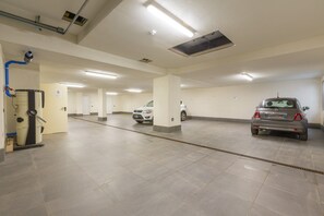 A parking garage with multiple levels, a water filtration system, and a few parked cars.