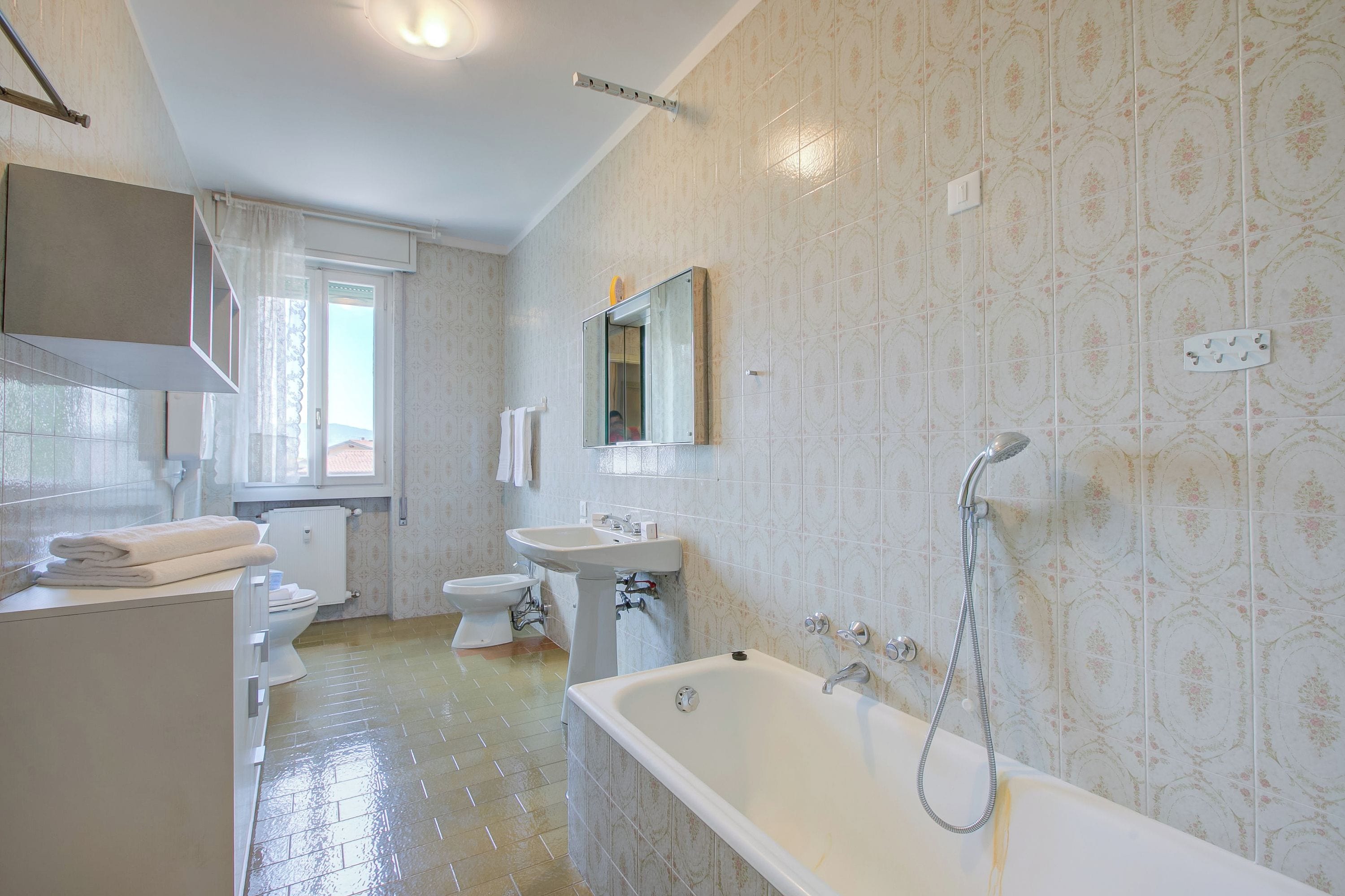 Un baño con bañera, lavabo, inodoro y espejo.