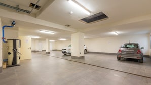 A parking garage with multiple levels, a ventilation system, and a few parked cars. - Casa Luminosa Ski in -Ski out 100m (Livigno)