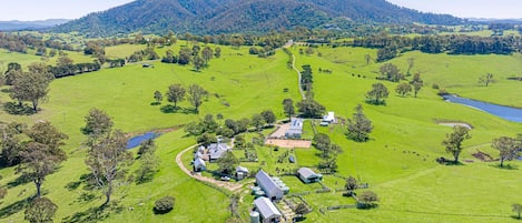 A rural property with multiple buildings, a winding path, and a lake.