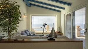 A cozy living room with a telescope, a plant, and a view of the sea through large windows. - Domus of the Sea: villa with cliffside pool in the heart of Gallura (Trinità d'Agultu e Vignola)