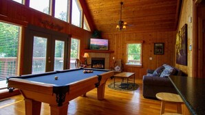 A wooden-floored room with a pool table, a fireplace, and a couch. - Create Memories this Spring Break | Smoky Waters (Sevierville)
