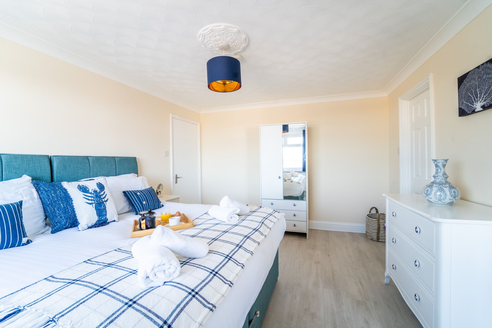 Ein Schlafzimmer mit Bett, Nachttisch, Schminktisch und Spiegel.