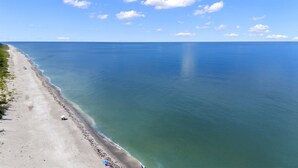 A beach with a clear view of the ocean, a sandy shore, and a few umbrellas. - Wiles Drive (Captiva)