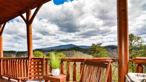 A wooden deck with a view of mountains and trees. - Rustic Mountain Retreat ~ Panoramic Mountain View ~ Hot Tub ~ Game Room  (Sevierville)