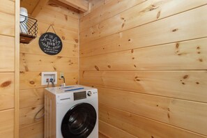 A laundry room with a washing machine, a wall-mounted basket, and a sign that reads 'The Laundry Room.' - Mtn Lodge~Hot Tub+Fire Pit+Fireplace, WiFi! (Burnsville)