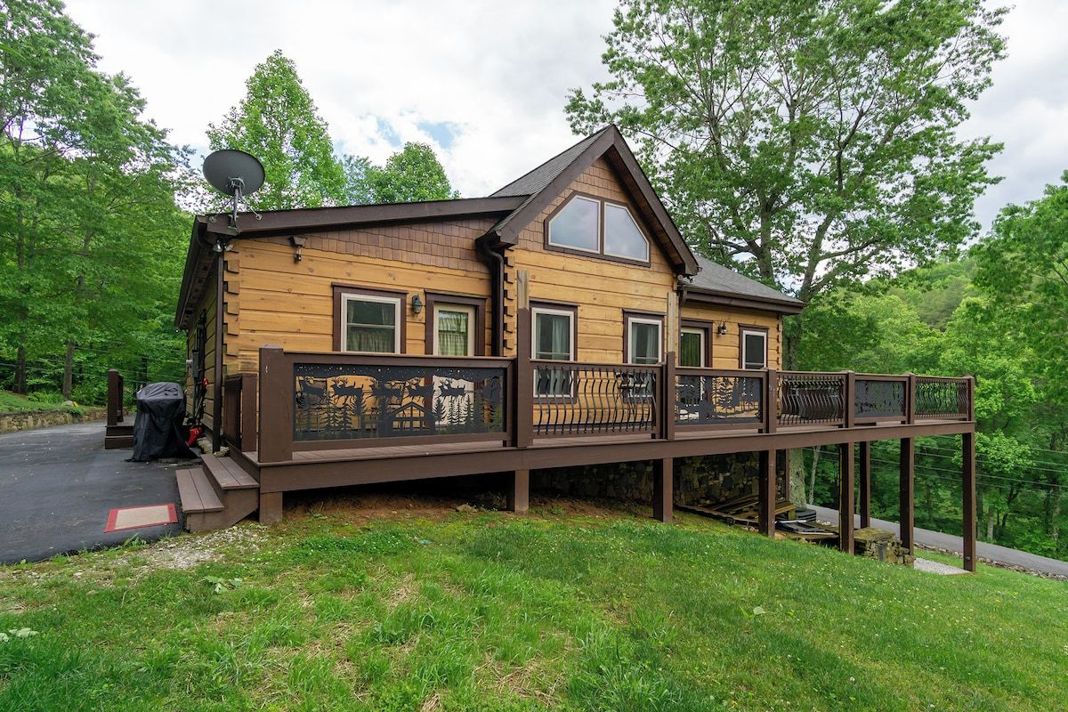 Een houten chalet met terras, omringd door bomen.