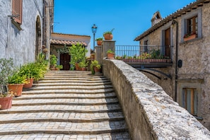 A stone staircase leading to a building with potted plants and a metal railing. - Torre Del Melograno With Heated Pool (Castiglione in Teverina)