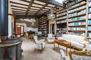 Una biblioteca con scaffali, un tavolo da biliardo e mobili antichi.