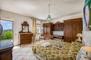 A bedroom with a bed, wooden dresser, and a desk. - Torre Del Melograno With Heated Pool (Castiglione in Teverina)
