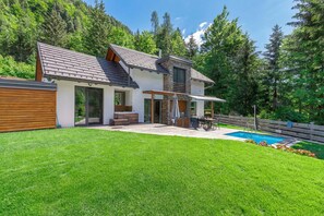 A modern house with a swimming pool, a wooden deck, and a lush green lawn. - Pool Villa Katja Near Kranjska Gora (Kranjska Gora)