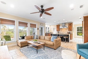 A spacious living area with a sofa, coffee table, and a ceiling fan. - Sea la Vie: Pool/Beach/History (St. Augustine)