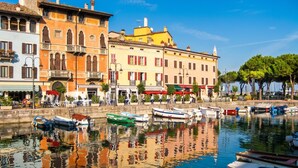 Un paisaje con edificios, barcos y un cielo despejado junto al agua.