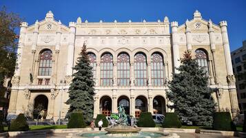 A grand building with a central fountain, symmetrical architecture, and statues.