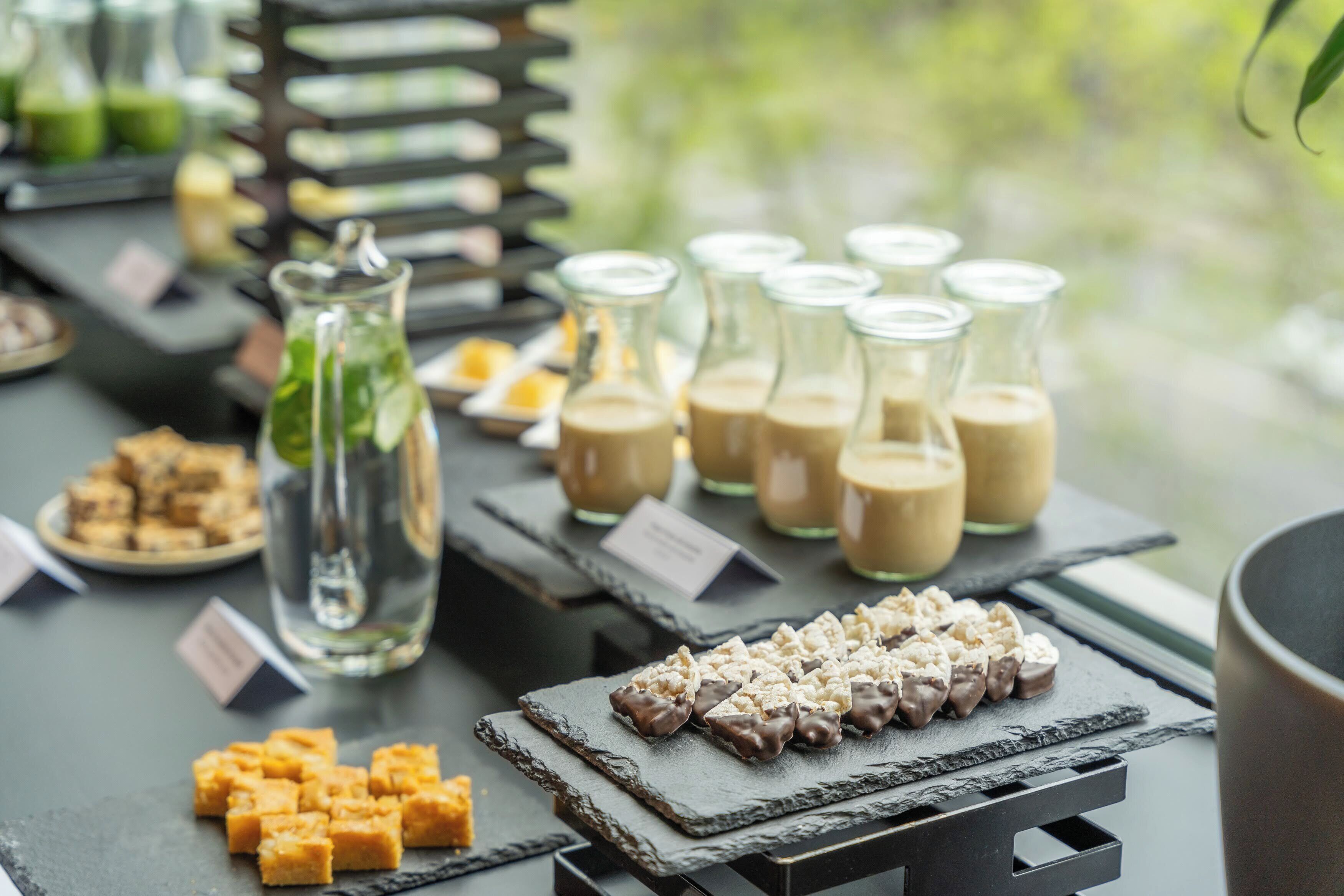 A table with various food items and drinks, including jars of beverages and a pitcher of water.