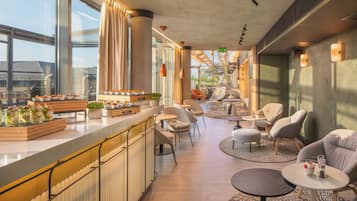 Un interior moderno con zona de bar, asientos y grandes ventanales.