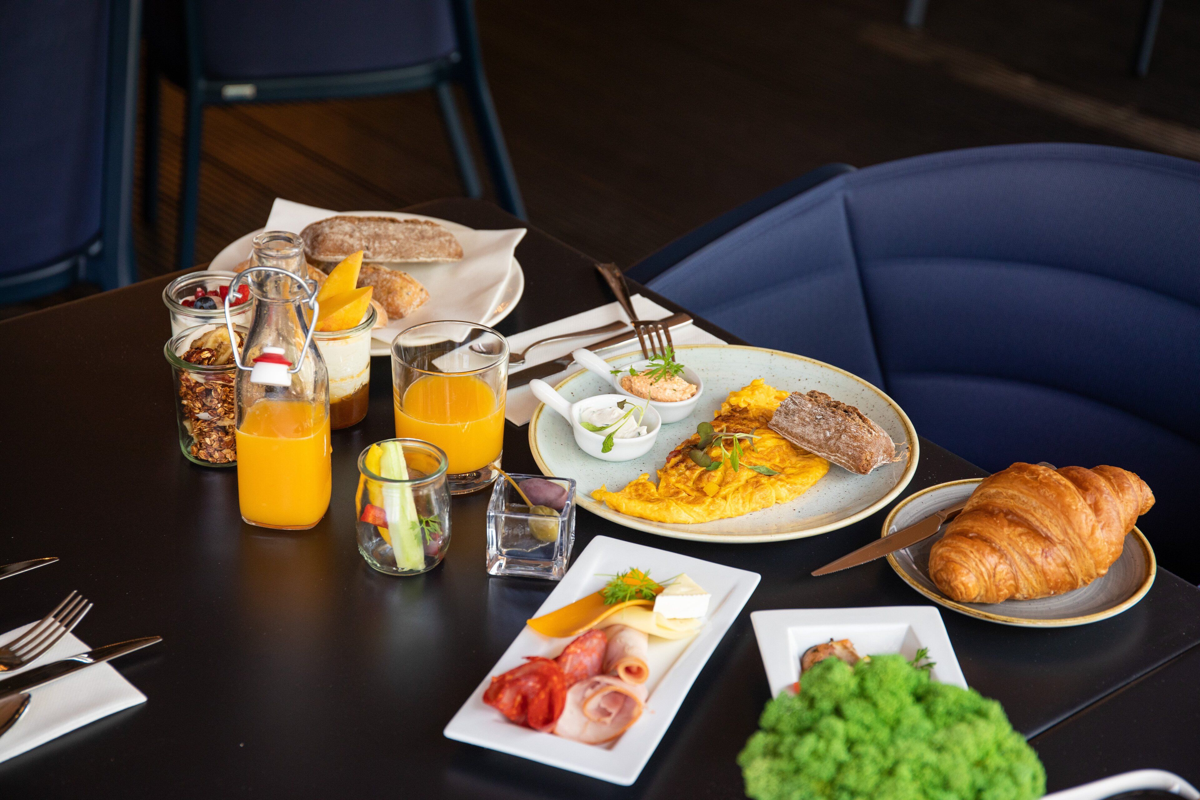 A breakfast table with various food items and drinks.