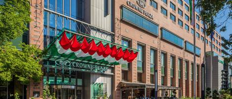 A hotel with a prominent entrance, large windows, and a green awning.