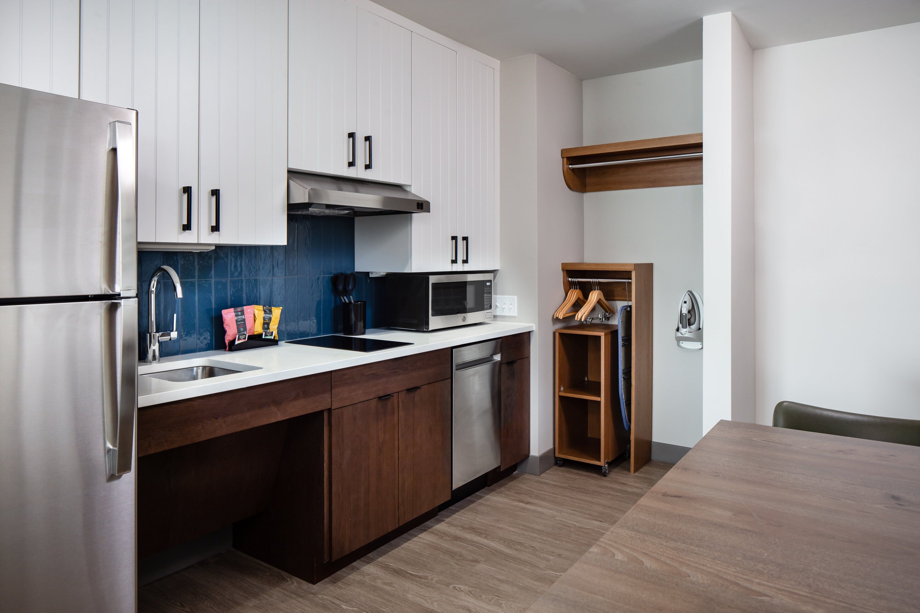 Una cocina moderna con electrodomésticos de acero inoxidable, armarios de madera y microondas integrado.