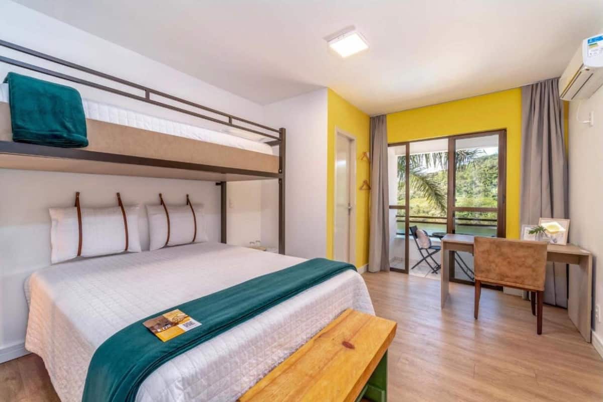 A room with a bunk bed, a desk, a chair, and a bench.