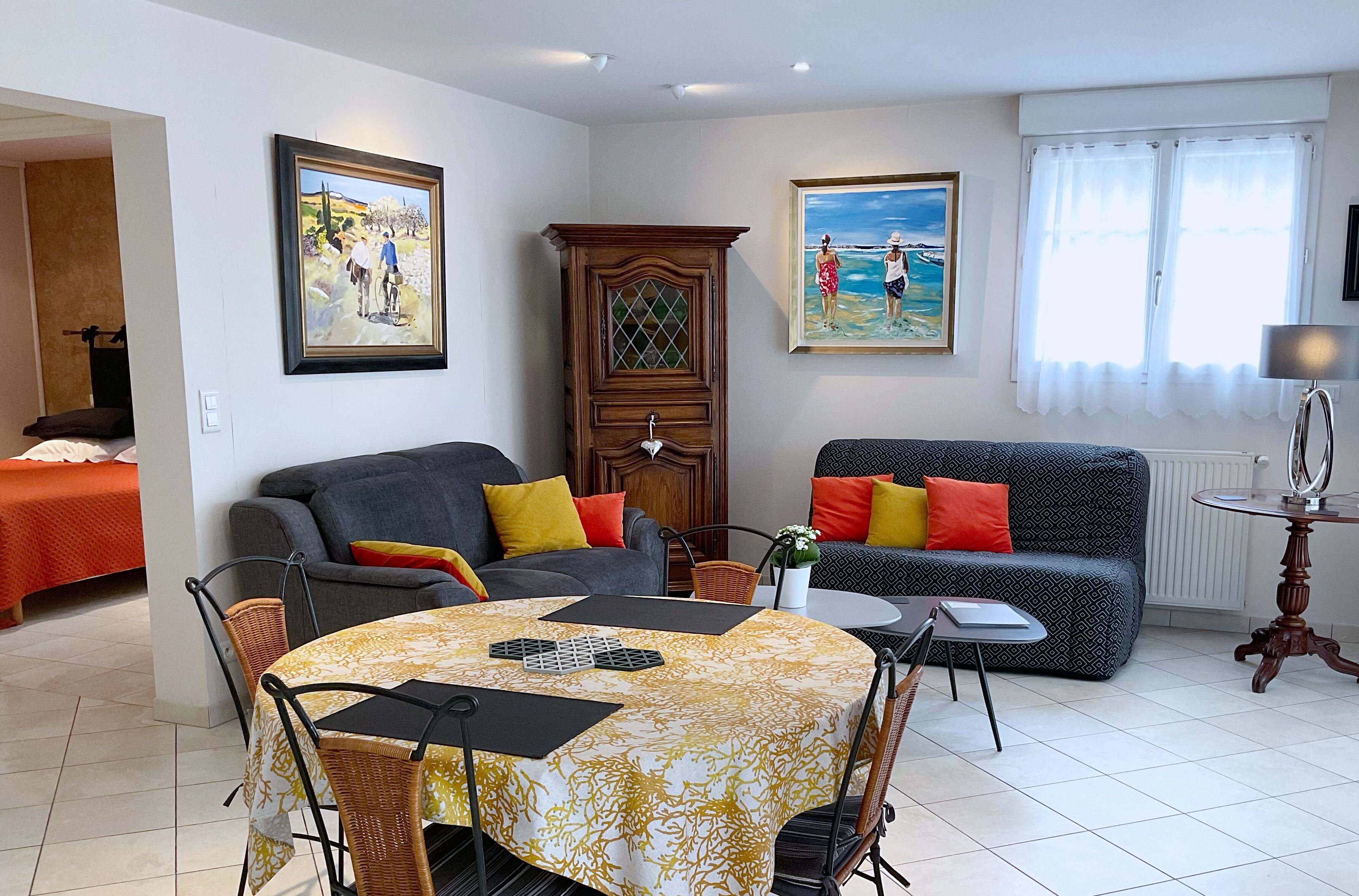 A living room with a dining table, two sofas, and a cabinet.