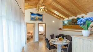 A dining area with a round table, chairs, and a potted plant. - Pool & Spa House Betiga 2 (Vodnjan)