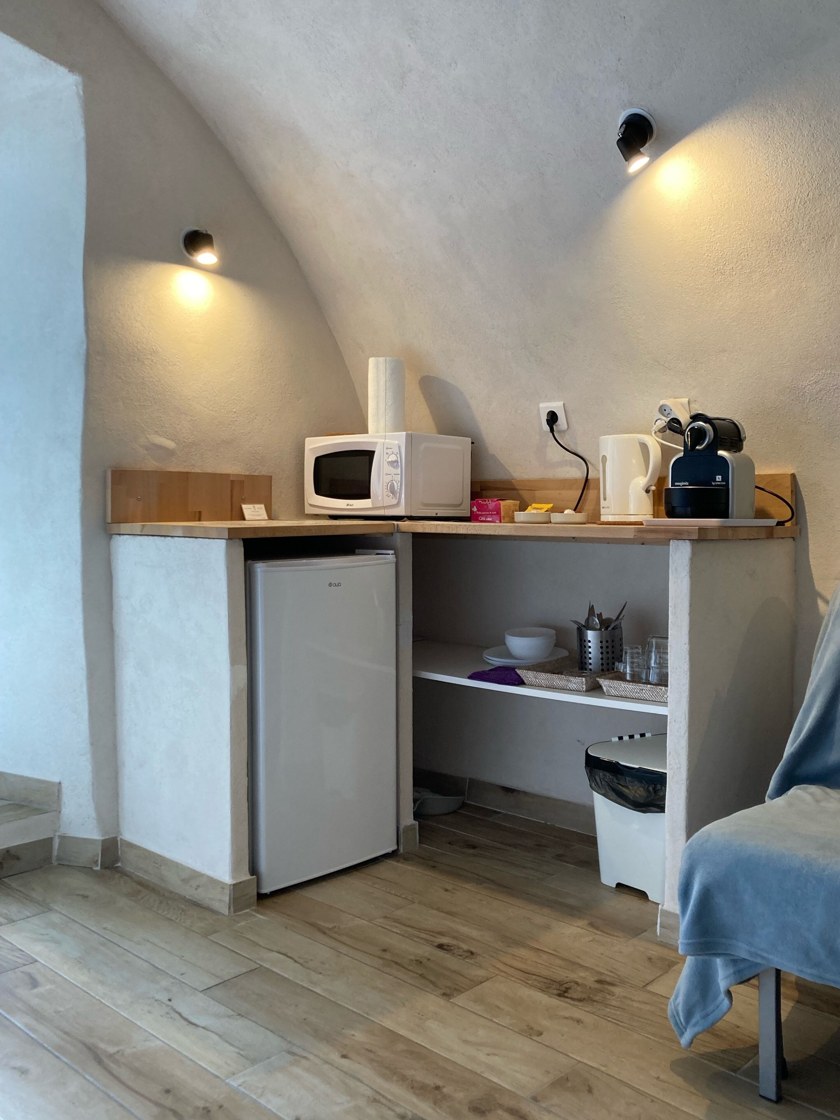 Una cocina compacta equipada con microondas, cafetera y refrigerador pequeño.