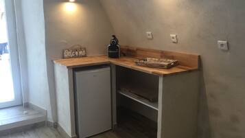 Una cocina compacta con refrigerador integrado, una encimera de madera y un cartel que dice 'Welcome'.