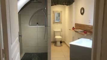 A bathroom with a shower, toilet, and sink.