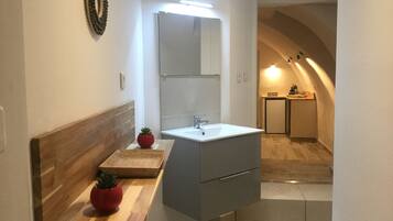 Une salle de bain moderne avec un meuble-lavabo en bois, un grand miroir et un lavabo encastré.
