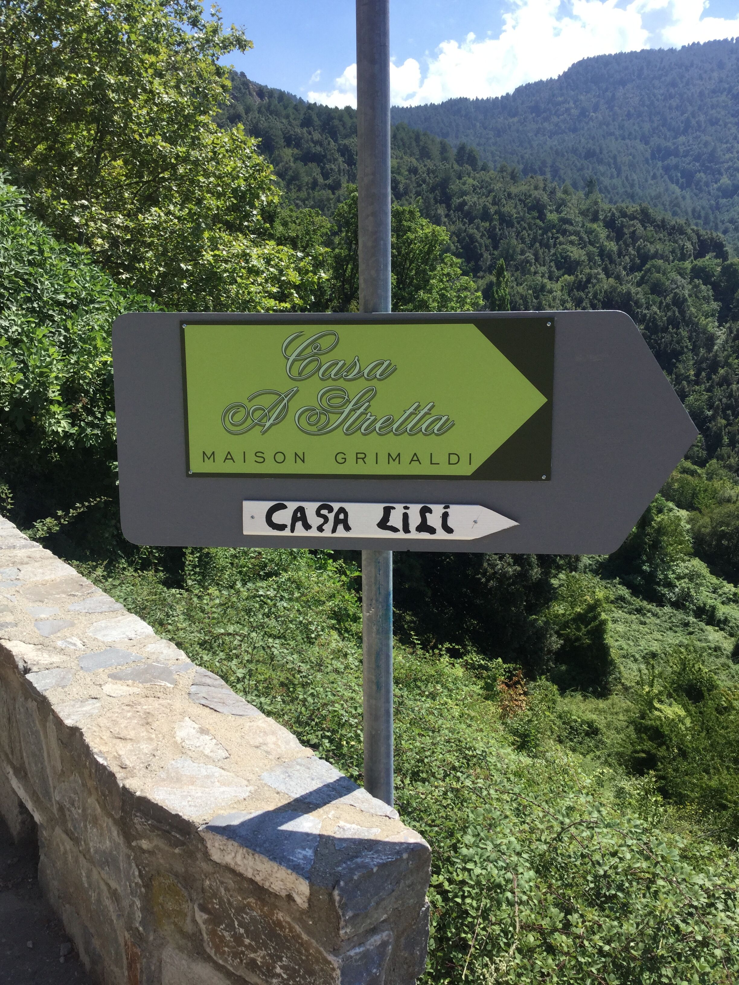 A directional sign for Casa A Stretta, indicating the direction to Maison Grimaldi and Casa Lili.