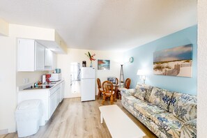 Un espacio habitable pequeño con kitchenette, comedor y sofá.