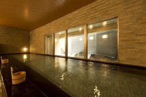A spacious indoor area with a polished floor, wooden ceiling, and brick walls. - Village Kyoto (Kyoto)