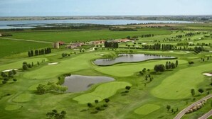 Ein Golfplatz mit mehreren Bunkern, Wasserhindernissen und einem Clubhaus.