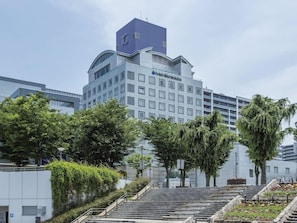 A hotel with a modern design, featuring a prominent entrance with steps leading up to the main building. - Okura Frontier Hotel Tsukuba (Tsukuba)