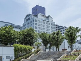 A hotel with a modern design, featuring a prominent entrance with steps leading up to the main building.