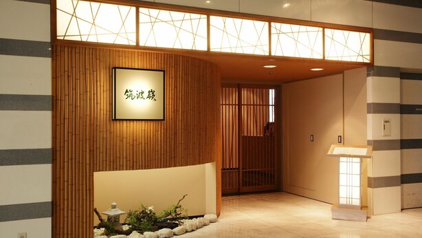 Un espace d’accueil avec un comptoir de réception en bois, un petit autel et une pancarte indiquant une salle privée.
