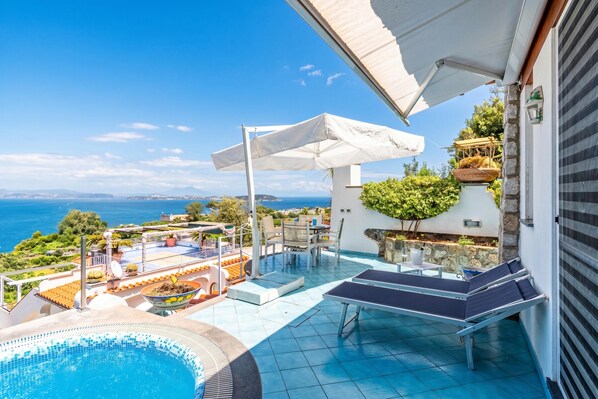 Ein Poolbereich auf dem Dach mit Meerblick, Sitzgelegenheiten im Freien und einer Pergola.