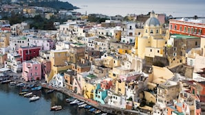 A densely packed coastal town with colorful buildings, a prominent church with a dome, and boats docked along the waterfront. - Dependance Castiglione With Pool And View (Casamicciola Terme)