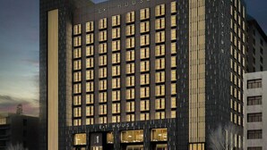 A multi-story hotel with a dark facade and illuminated windows. - Xi'an Eastern House Boutique Hotel (Xi'an)
