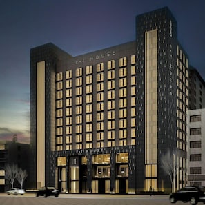 A multi-story hotel with a dark facade and illuminated windows.