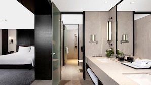 A modern hotel room with a large bed, a separate bathroom with a large mirror, and a walk-in shower. - Xi'an Eastern House Boutique Hotel (Xi'an)
