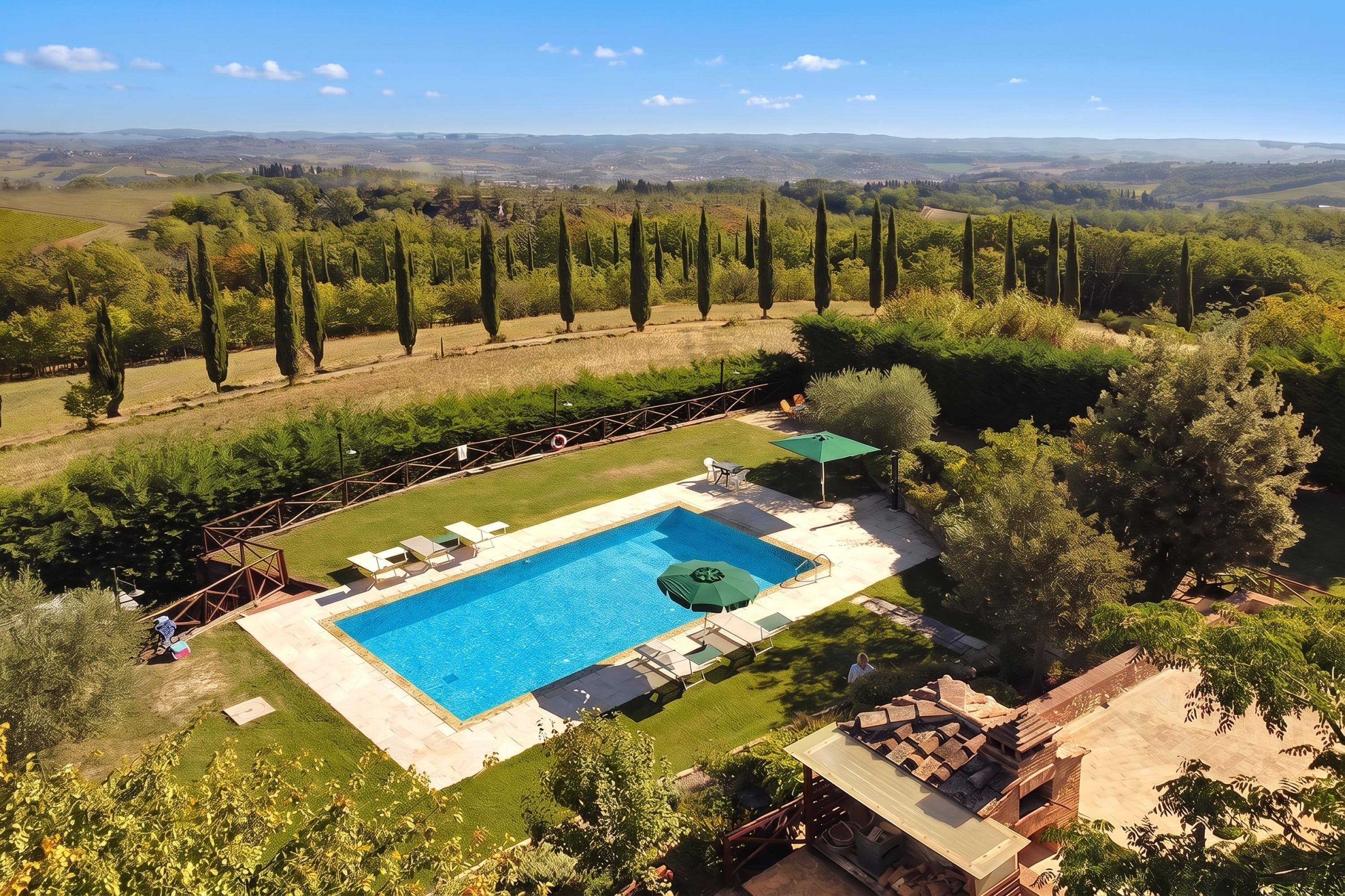 A swimming pool with a surrounding deck, a pergola, and a view of the countryside.