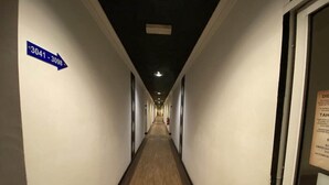 A long, narrow hotel corridor with white walls and wooden flooring. A blue directional sign on the left indicates room numbers 3041-3098. - Super OYO 89847 Switz Paradise Hotel (Kota Kinabalu)