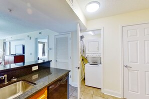 Kitchen features an oven, stainless steel sink, and a washing machine.