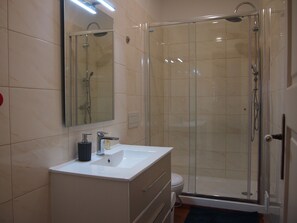 Habitación estándar doble | Baño | Ducha, cabezal de ducha tipo lluvia y toallas