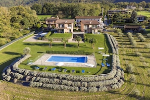 A large building with a swimming pool, surrounded by a stone wall, and a well-maintained lawn. - Margherita (Colico)